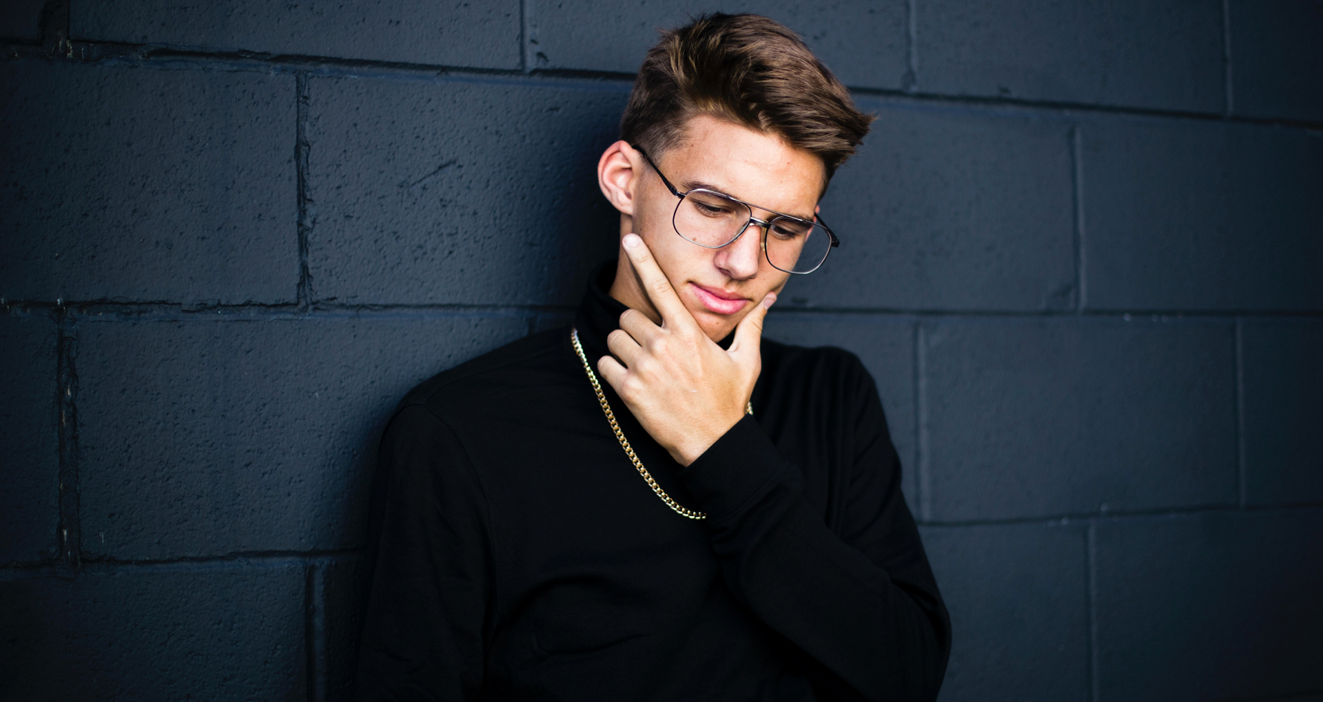 time-to-think young man leaning on blue wall thinking